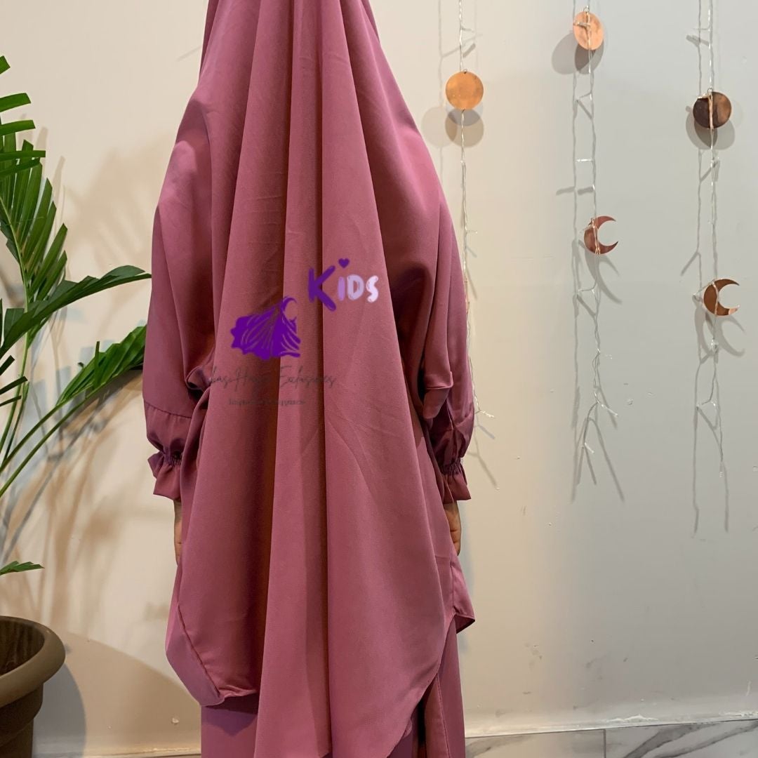 back of girl standing in pink abaya jilbab dress