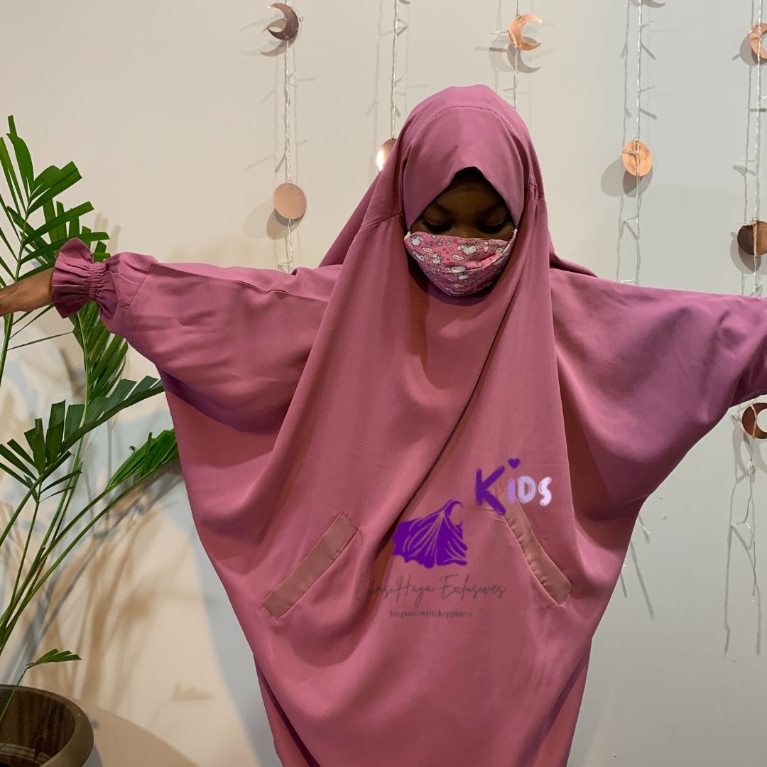 muslim girl standing witharms out in pink abaya jilbab dress