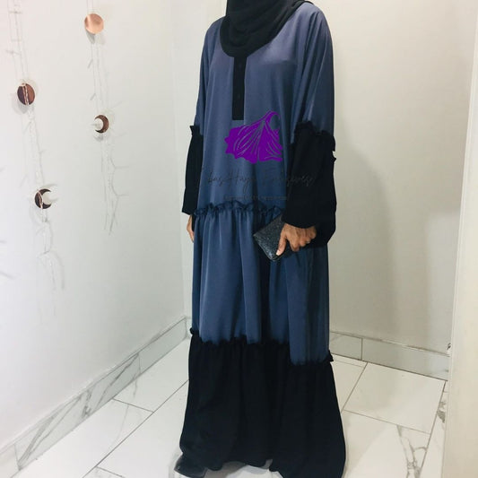 muslim woman standing in ruffle abaya 